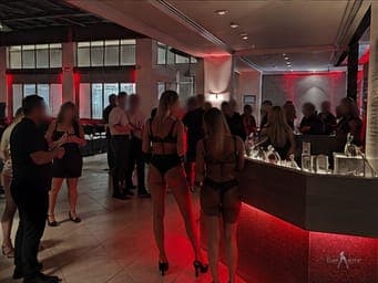 Guests at the lobby lounge bar during a TampArotic Tampa Bay event — faces blurred for privacy.